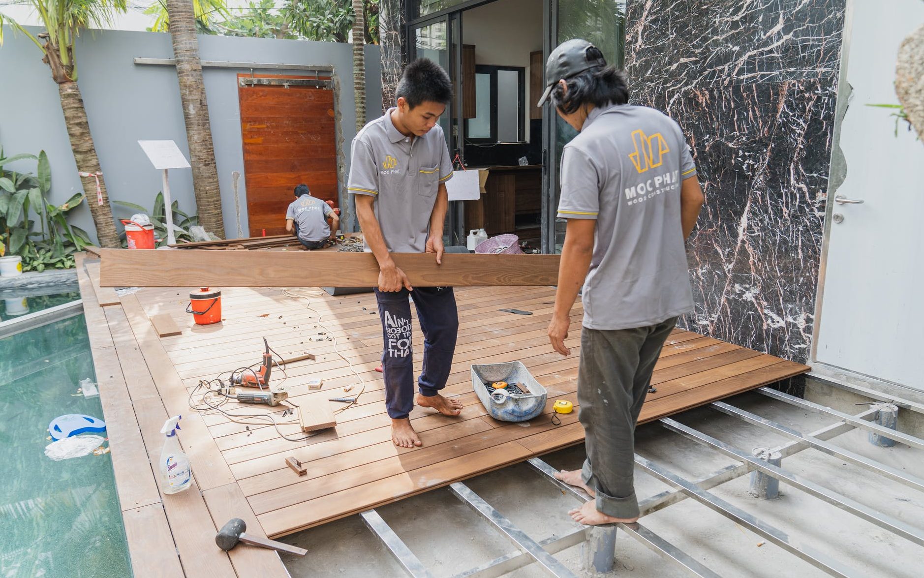 workers constructing the wooden floor of a house